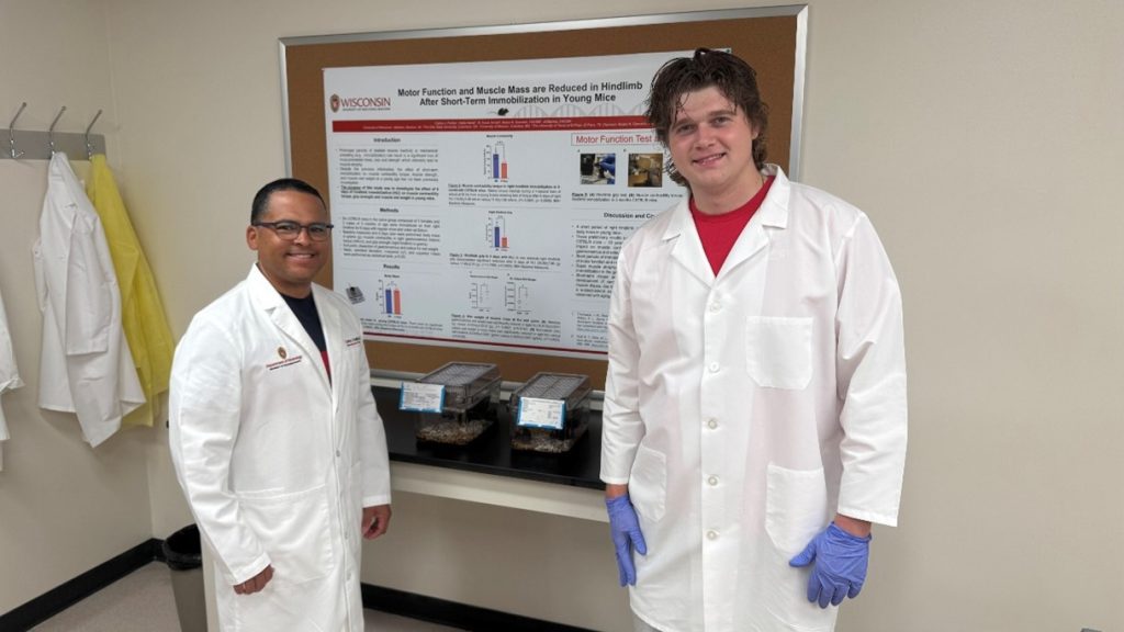 Padilla and student standing in front of a board with results