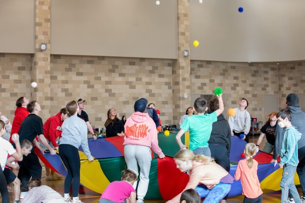 students working with kids in a physical education class
