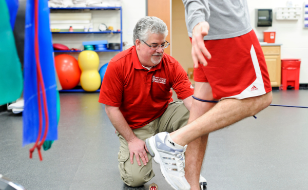 athletic trainer examining someone's leg