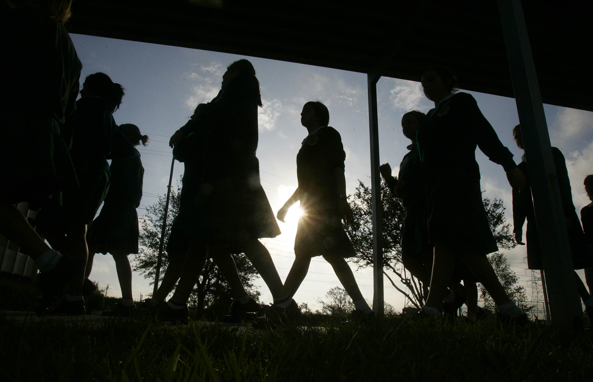 silhouettes of people walking past a window